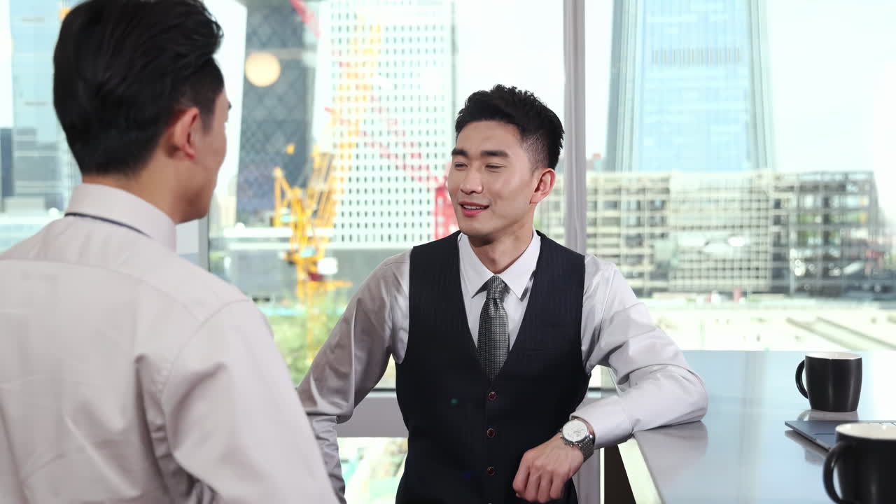 兩位合作夥伴，同為專業商務人士團隊，在現代辦公室內圍繞會議桌工作，利用手提電腦及咖啡，共同討論專案，氣氛融洽，有助促進高效益交流。可供文字使用。