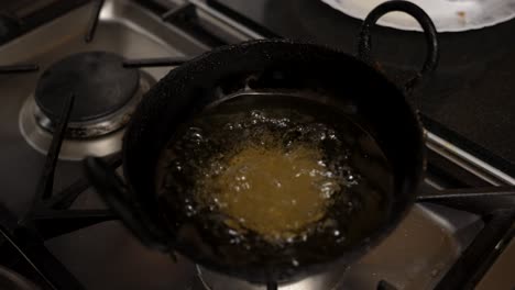 Overhead-View-Of-Bubbling-Guror-Handesh-In-Hot-Oil-Pan-On-Cooker