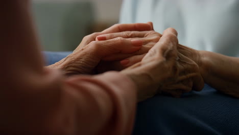 a person gently holding the hand of an elderly person