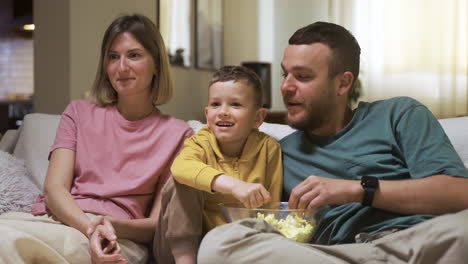 familia sentada en el sofá y viendo una película