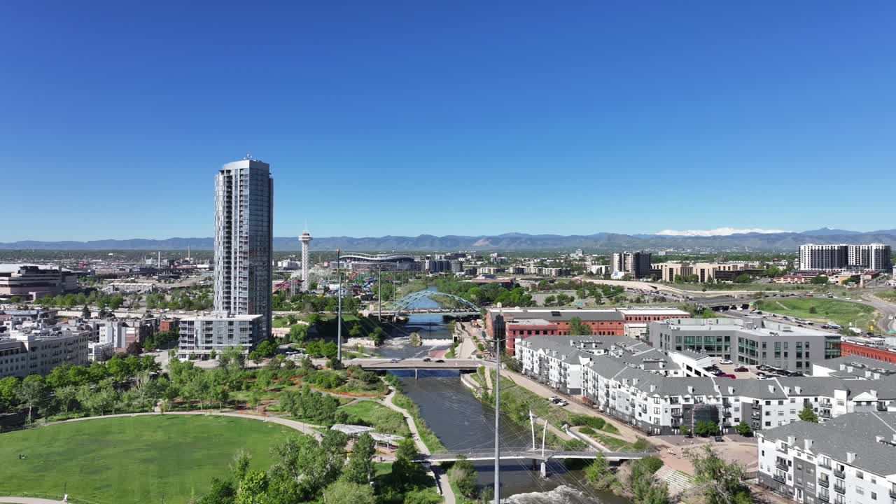 Vista aerea di Denver con lo stadio dei Broncos in lontananza mentre il drone vola lateralmente sotto un cielo azzurro limpido