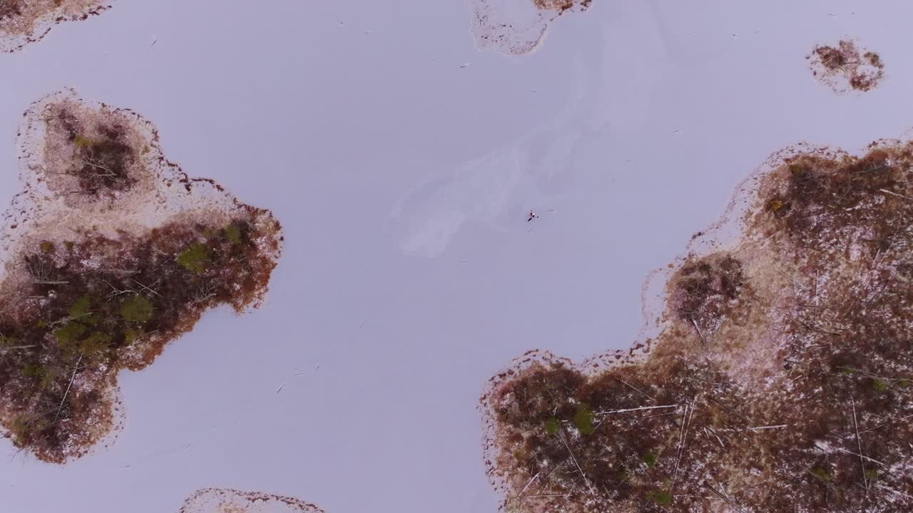 Lonely skater draws elegant paths on icy Skaista Lake in Cenu Bog’s stillness