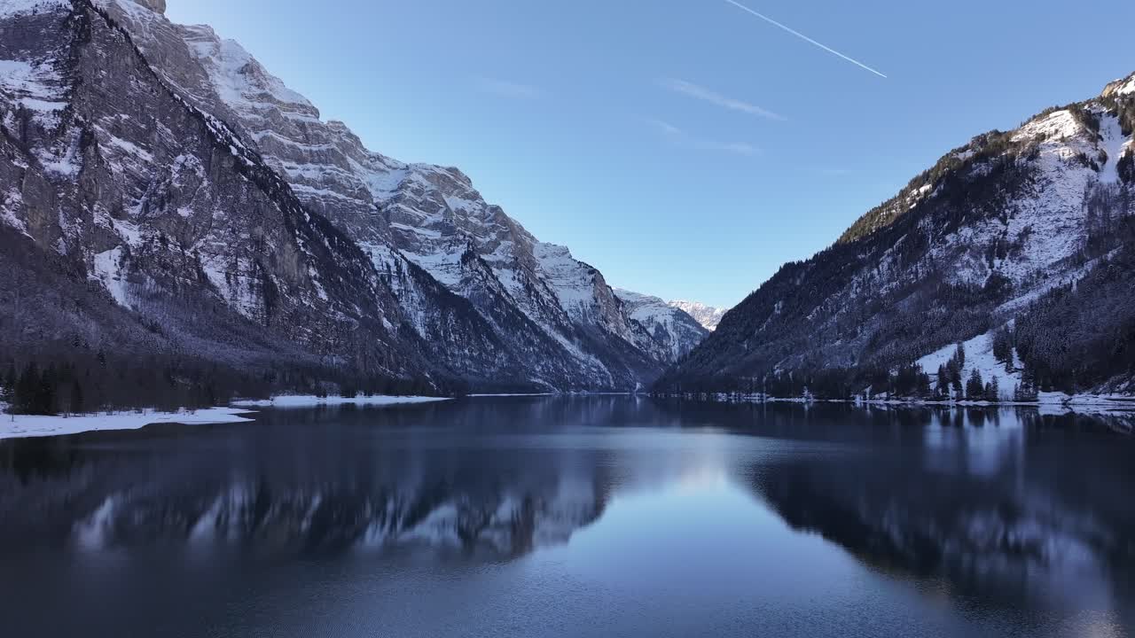 Low-flying drone footage over a nearly frozen lake in the Swiss Alps. Drone 4k.