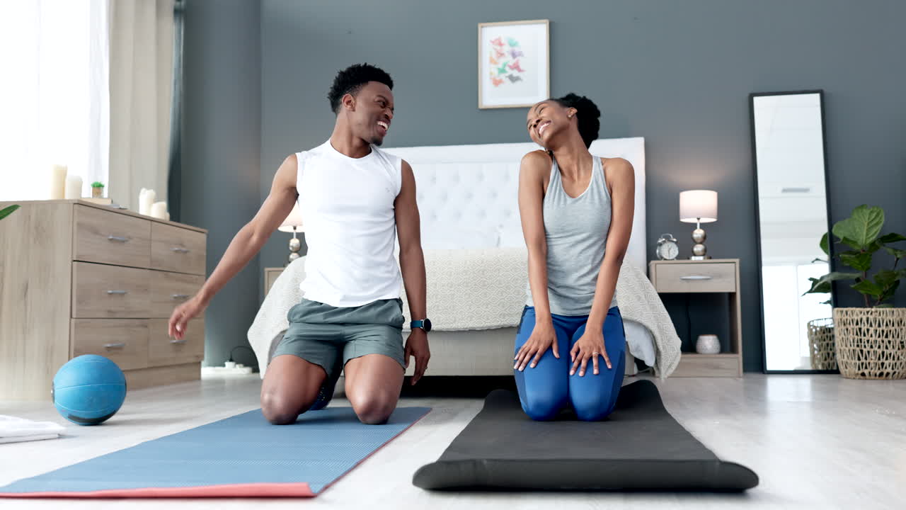 Black couple doing a workout in their bedroom