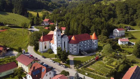 aerial approaching shot of olimje castle with parking cars sensurround by beautiful green landscape in slovenia