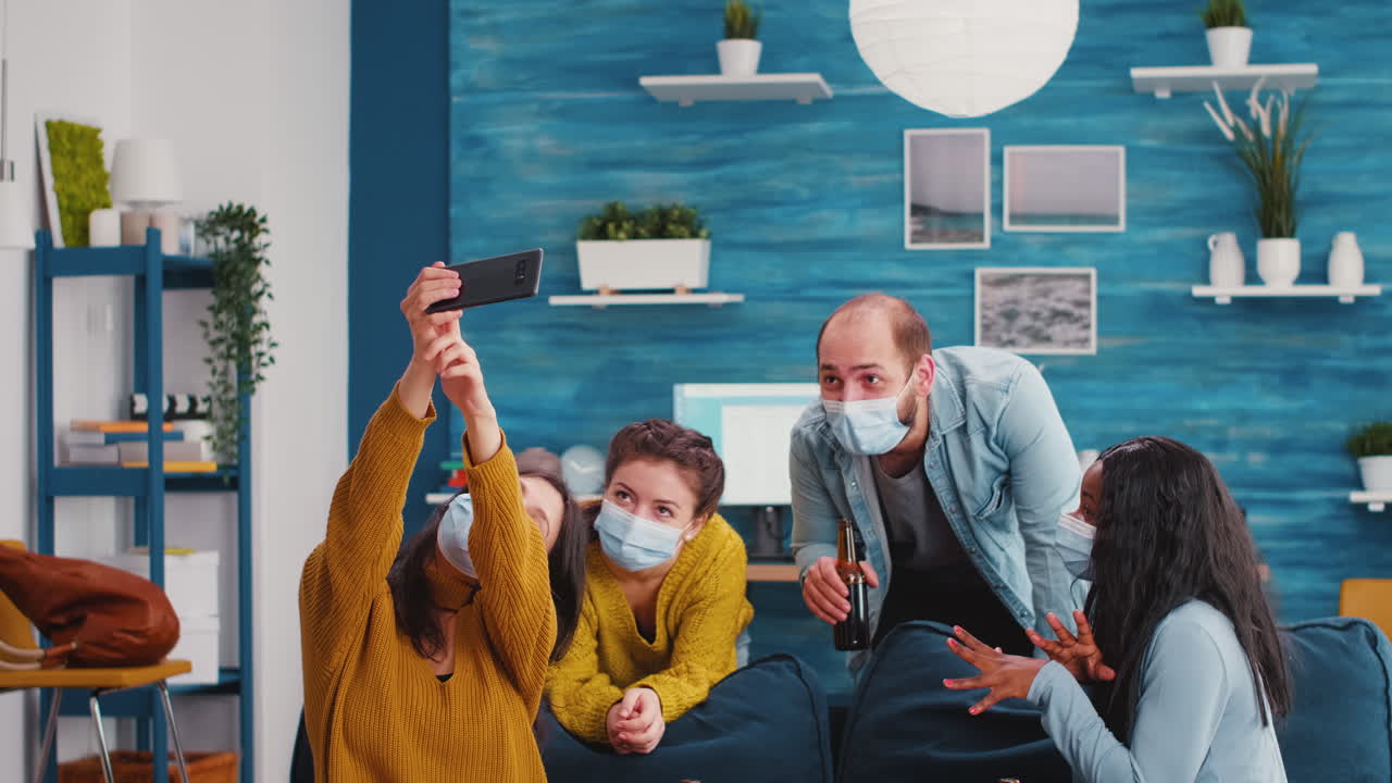 Young people from diverse cultures taking selfie wearing face masks