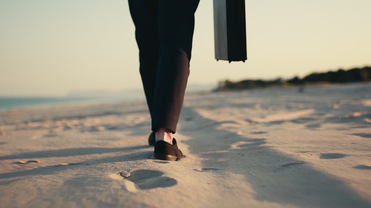 Uomo d'affari che cammina sulla spiaggia con una valigetta