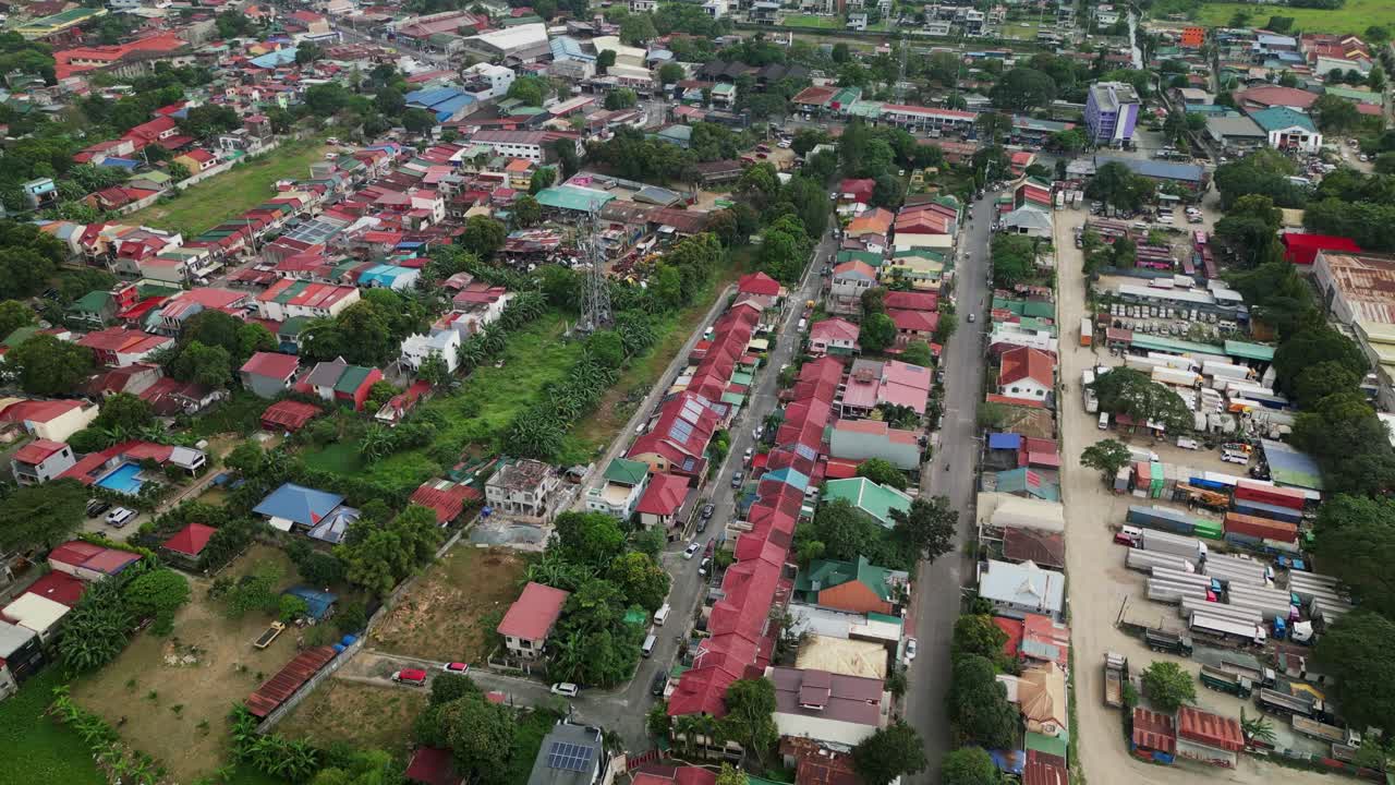Pemandangan udara lingkungan pinggiran kota dengan atap merah, ruang hijau, serta pengembangan perumahan dan industri campuran di Antipolo, Filipina.