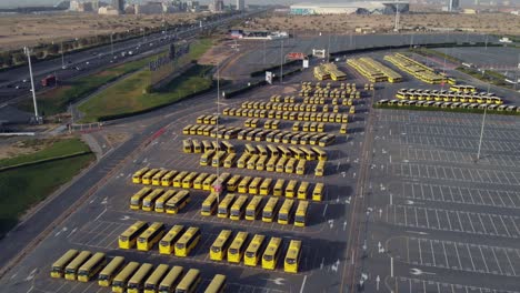 Out-of-order-yellow-buses-being-left-behind,-drone-view