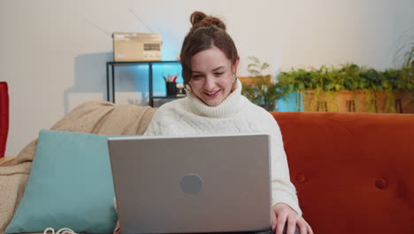 Woman-sitting-on-home-couch,-looking-at-camera,-making-video-conference-call-with-friends-or-family