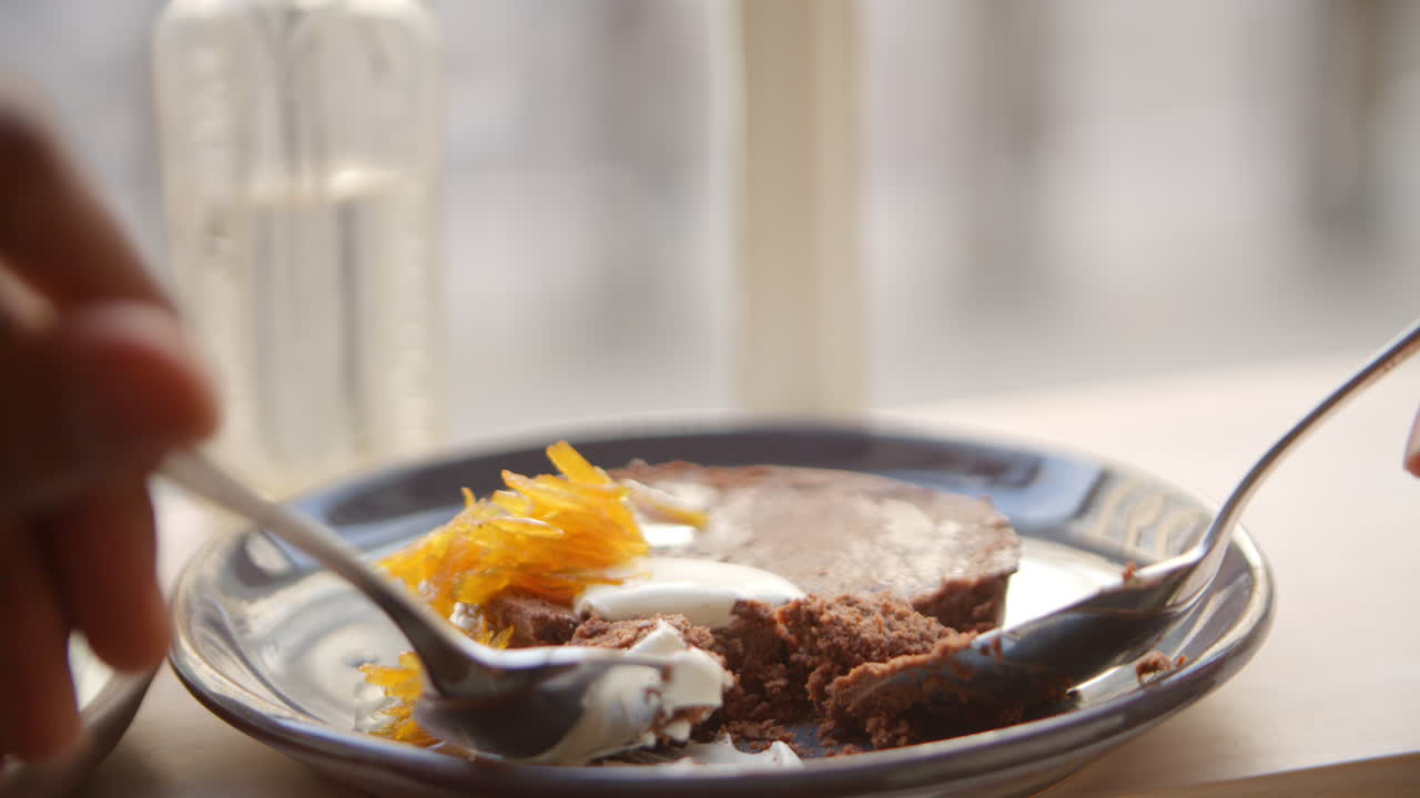 카페에서 초콜릿 브라우니를 먹는 두 사람의 가까운