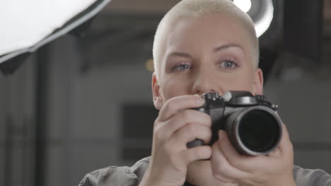 fotografo femminile che scatta foto durante la sessione di ritratto in studio 01