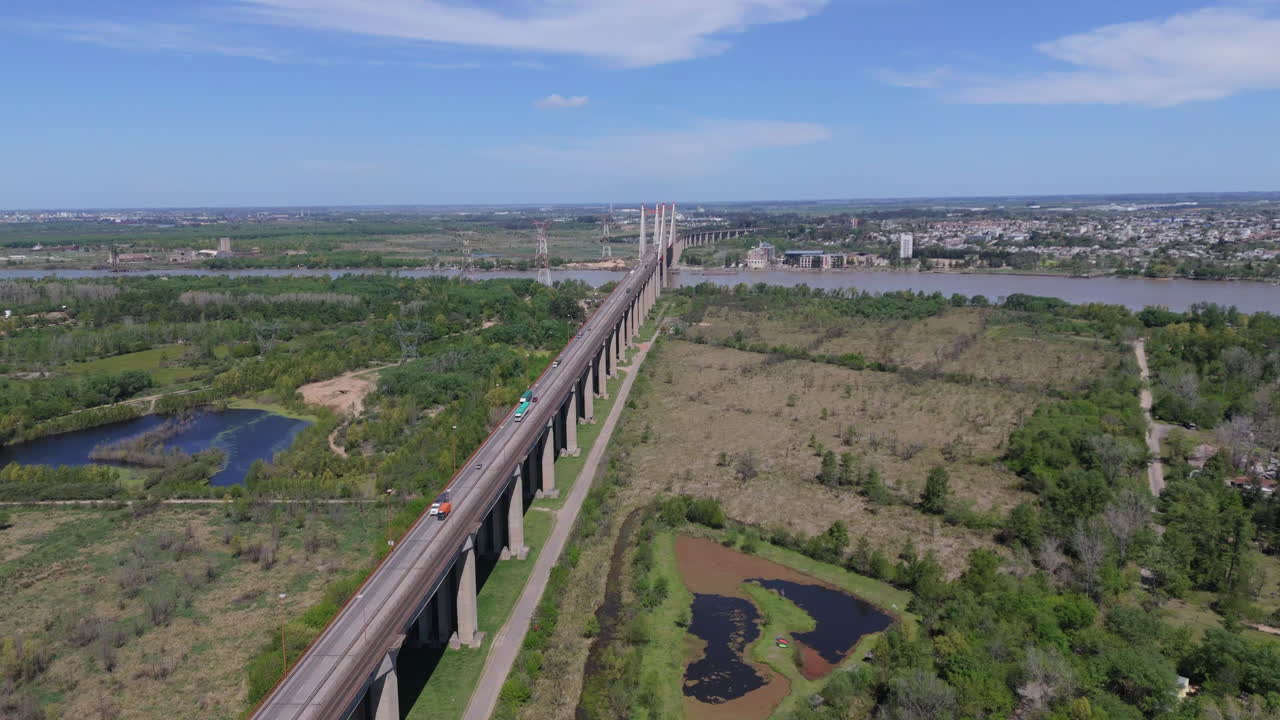 Flying over suspension bridge Zárate Brazo Largo over Paraná River with vehicles circulating, Argentina