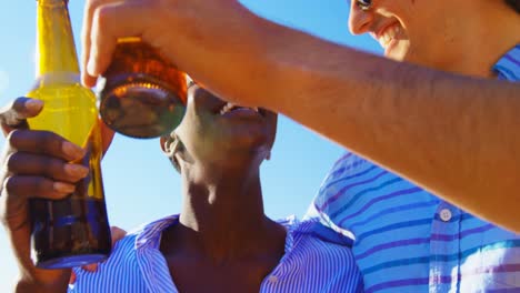 grupo de amigos brindando botellas de cerveza en la playa 4k