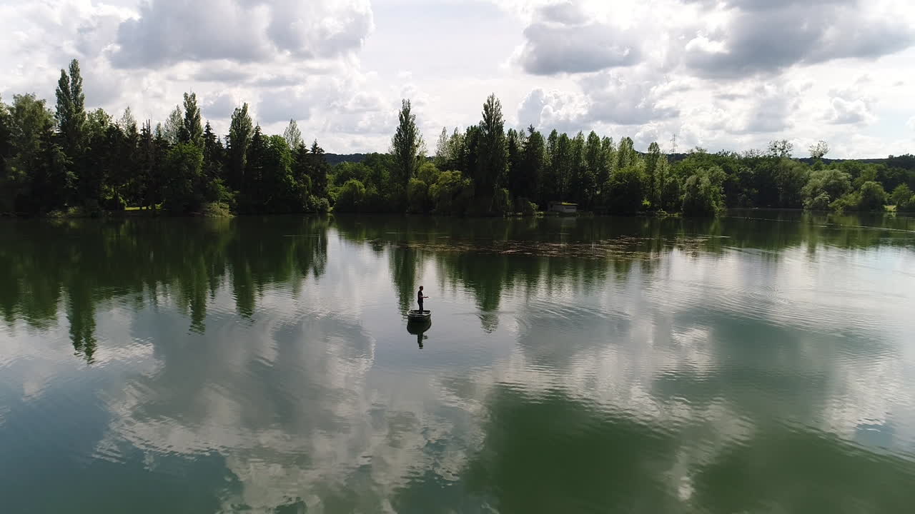 호수 한가운데에 배를 타고 시하는 남자. 공중 풍경 이 좋은 날