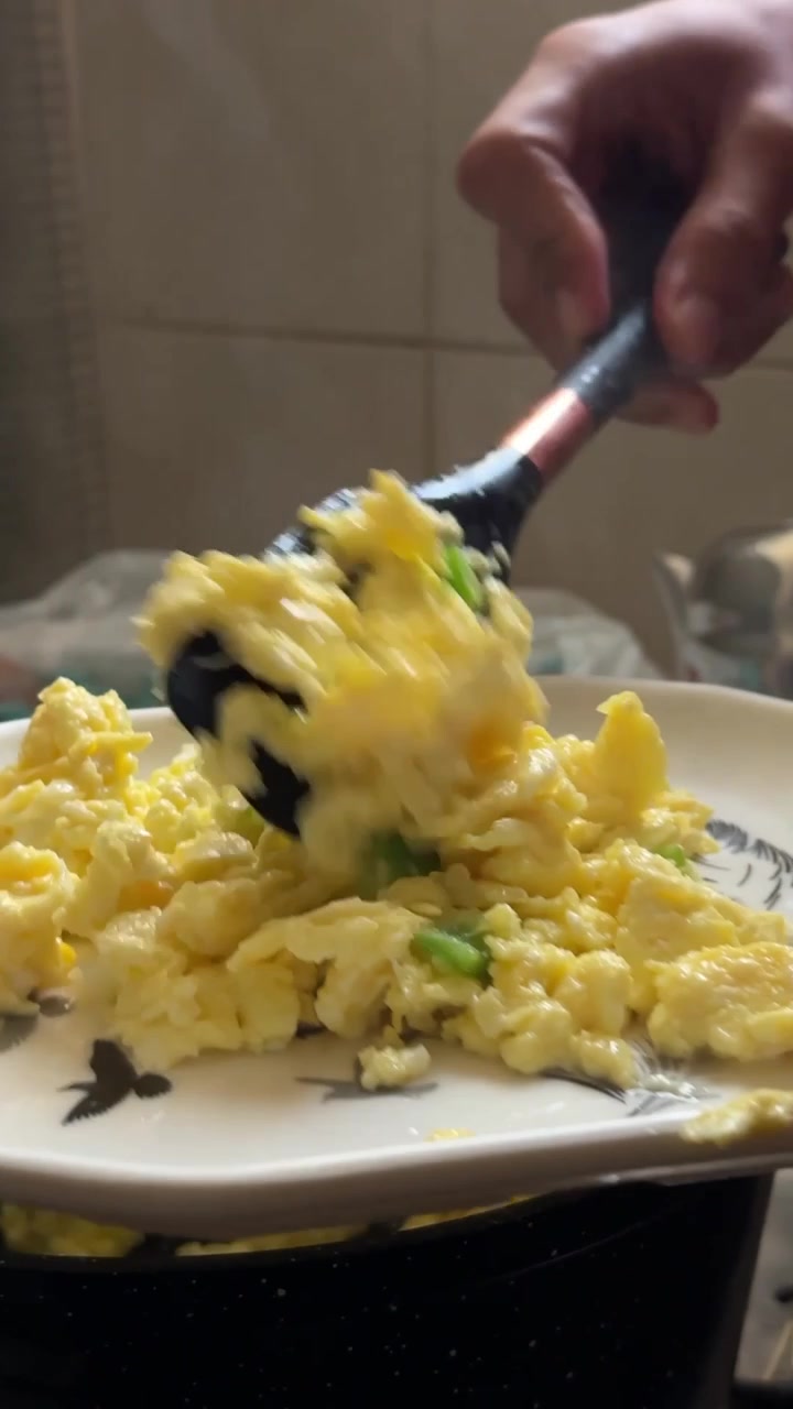 A chef wearing a white glove prepares creamy scrambled eggs on toasted bread with fresh salad, close up shot, insert shot