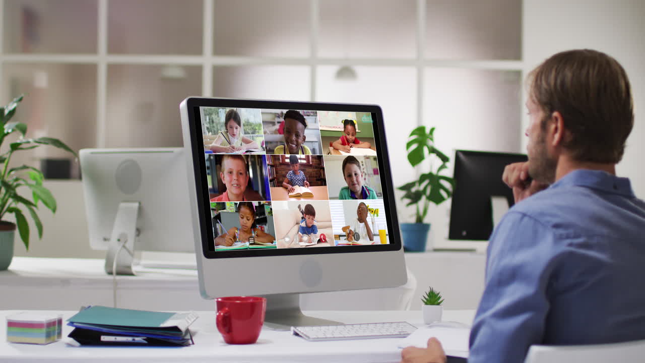 Caucasian male teacher using computer on video call with school children