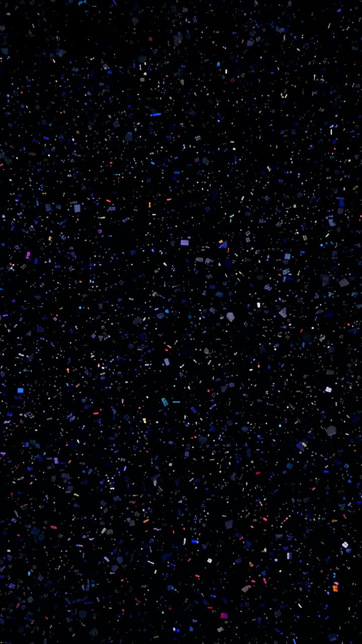 Video verticale: bagliore rosa emergente che illumina granelli fluttuanti che si muovono in un vuoto oscuro, rivelando il movimento