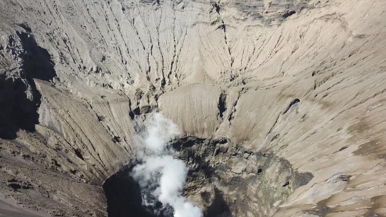 Seen from the drone, tourists are on the slopes of Mount Bromo, and the crater is visible.