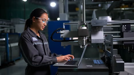 female engineer working on a cnc machine in a factory