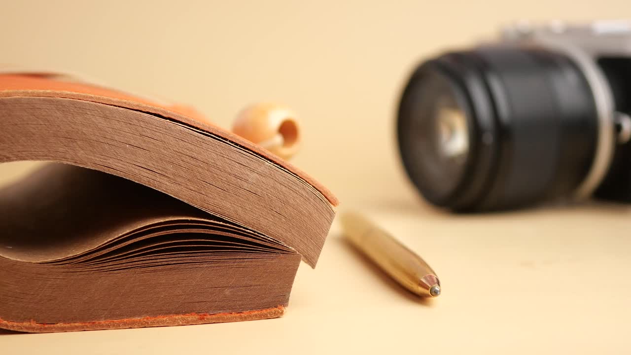 Still life with notebook, pen, and camera