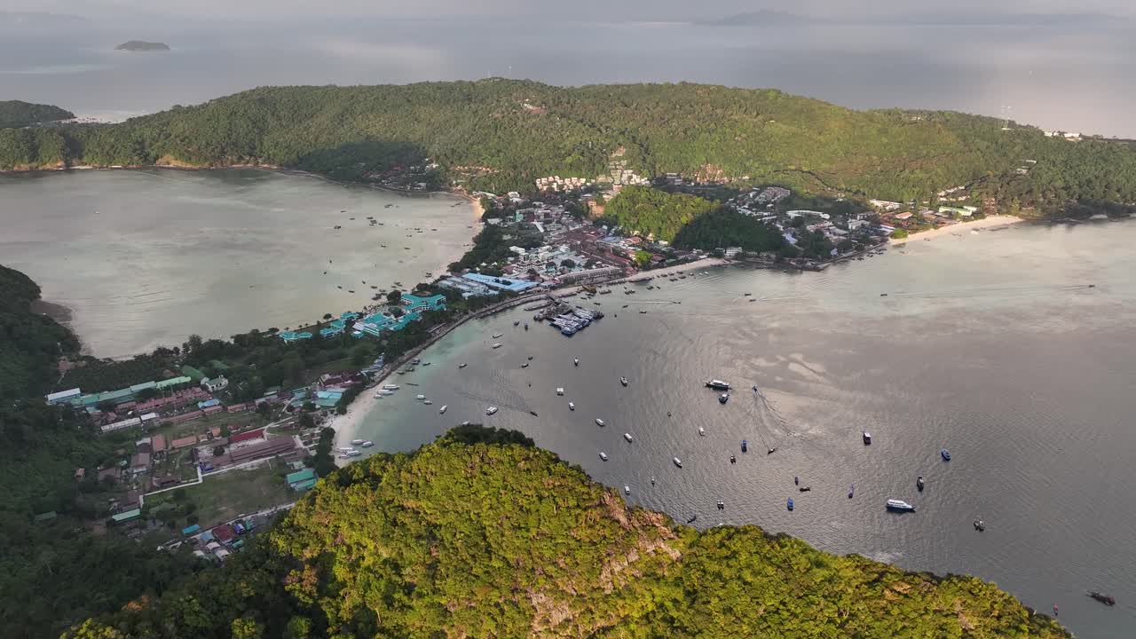 Amazing aerial of Koh Phi Phi Don and land strip with beaches, over the mountain during sunset.