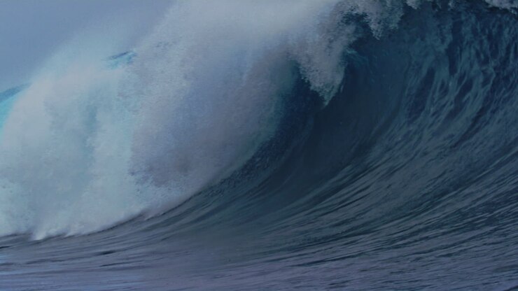 Breathtaking natural beauty of ocean wave crashing into whitewash on surface of water in slow motion