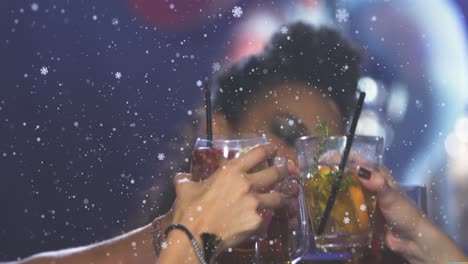 Animation-of-snowflakes-over-diverse-friends-at-bar