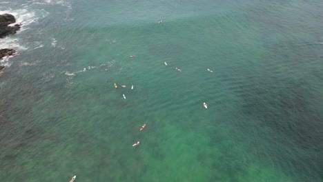 Surfing-heights,-aerial-view-of-surfers-riding-waves-at-Carrizalillo-beach,-Puerto-Escondido,-Oaxaca,-Mexico