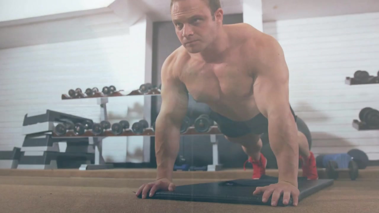 Man doing pushup reps on mat, lowering chest activating HUD code overlay on torso or head for fitnes