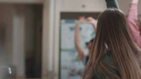 happy group of teenage girls dancing in kitchen having fun celebrating together enjoying hanging out together on party weekend