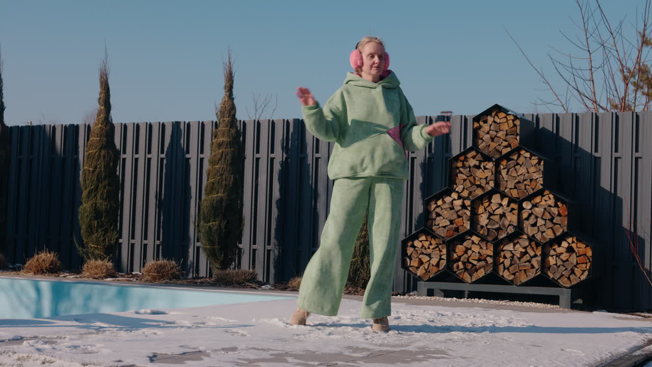 mujer bailando en la nieve junto a la piscina