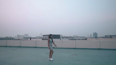 brunette-in-casual-dress-walks-along-roof-slow-motion