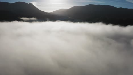 dense morning clouds backlit by the morning sun hangs above the valley