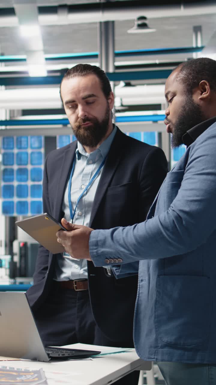 Vertical Video Diverse team of engineers and specialists collaborate in a solar panel factory
