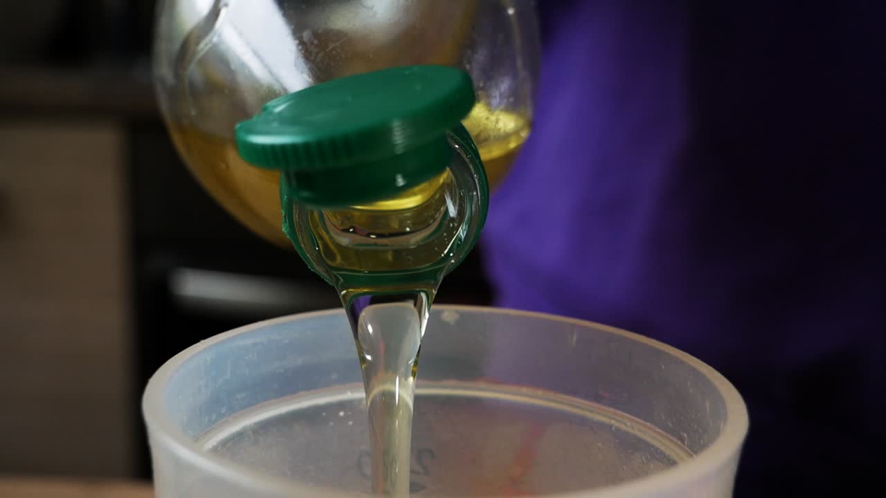 Pouring oil into bowl for homemade cooking. Homemade kitchen concept