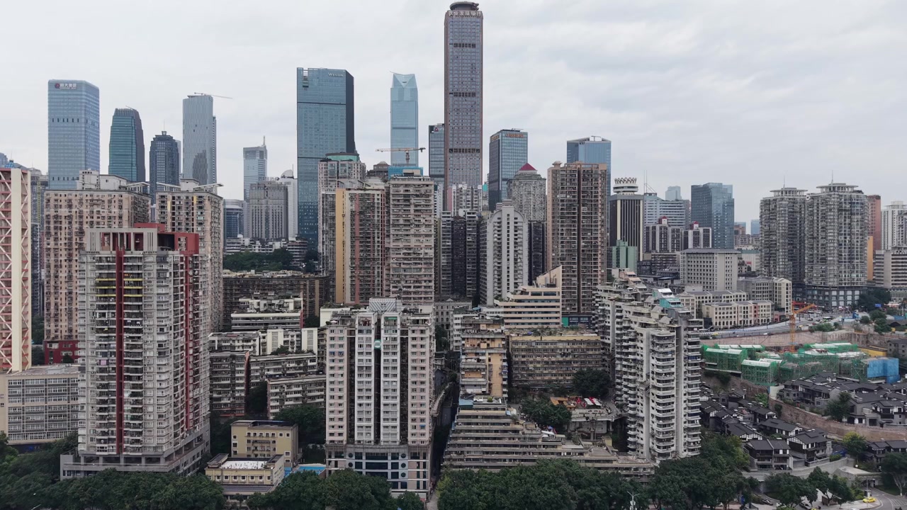 Avanço de drone em direção ao horizonte de Chongqing do outro lado do rio, torres residenciais e comerciais densas acima da orla, névoa encoberta, Chongqing, China