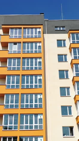 facade of a new apartment building. modern multi storey house with bright walls. block of flats with large balconies. front view. vertical video