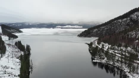 aerial shot of a partially frozen lake or reservoir in the middle of sweden during the midwinter solstice