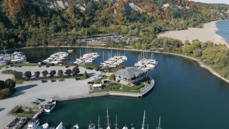 drone shot of a park that looks like an island with boats near a forest on a clear sunny day