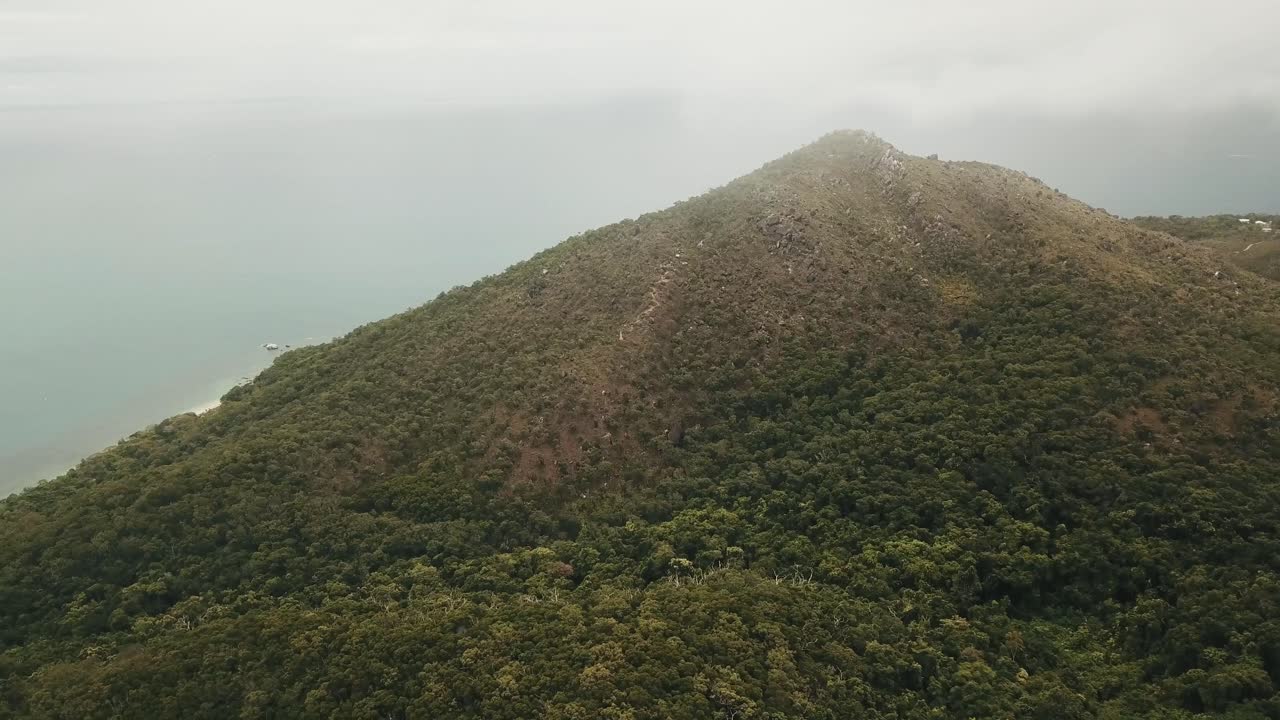 antena de drones en las nubes sobre el bosque tropical isla fitzroy mostrando agua azul en queensland