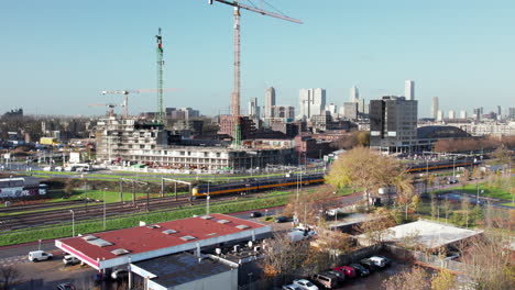 train and construction cranes in the city of rotterdam in netherlands in daytime