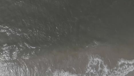 Calm-waves-of-Baltic-Sea-breaking-on-empty-beach-aerial-view