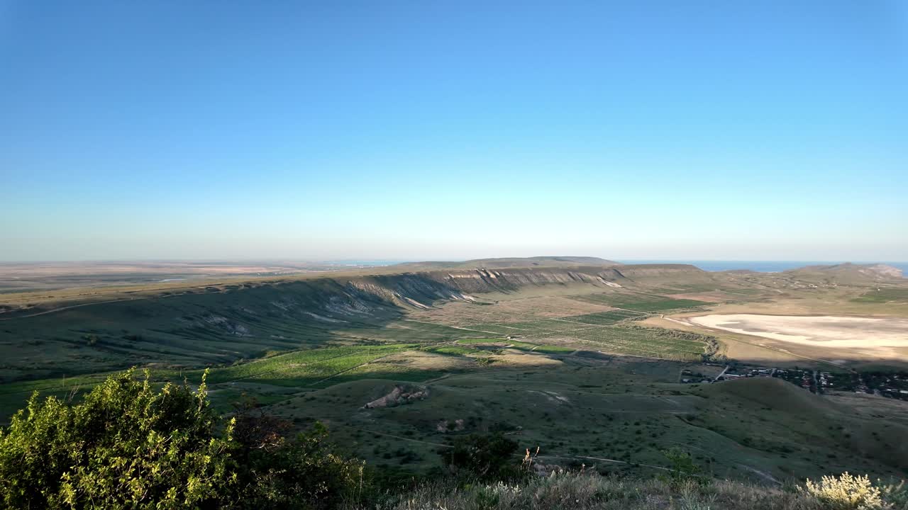 una impresionante vista de un valle en crimea con un cielo azul y colinas verdes
