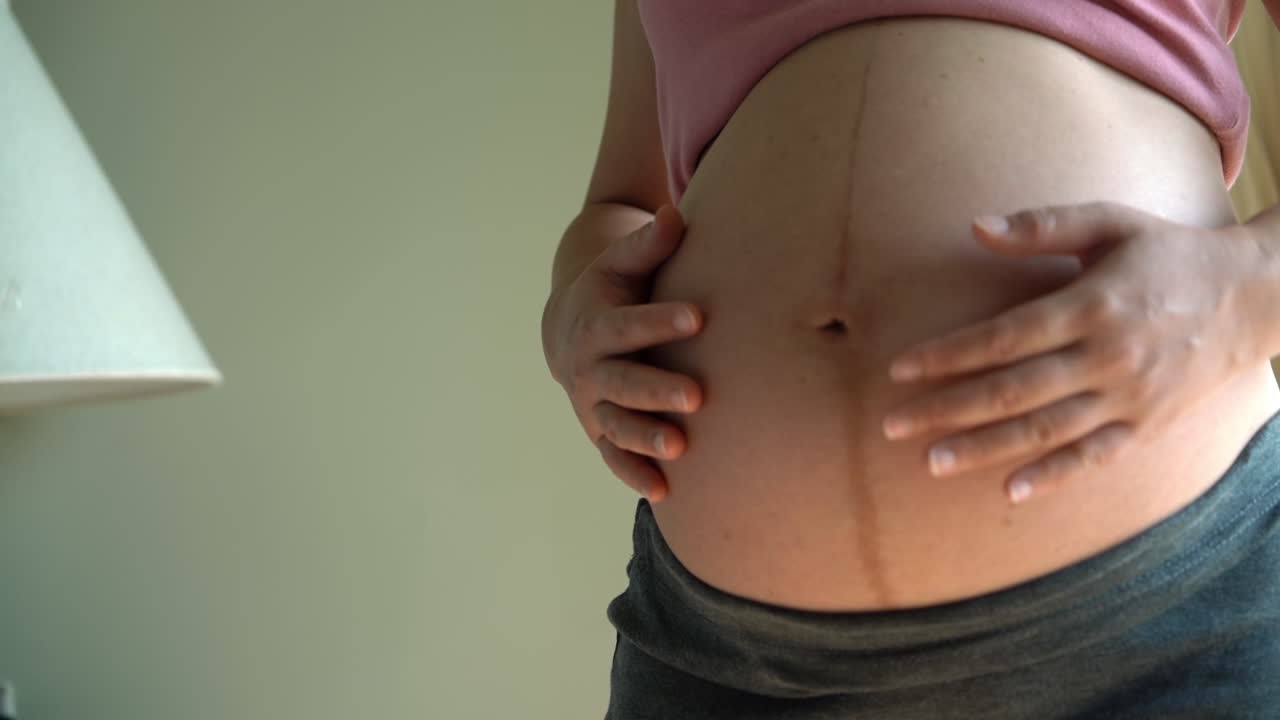 mujer embarazada feliz y esperando un bebé en casa.