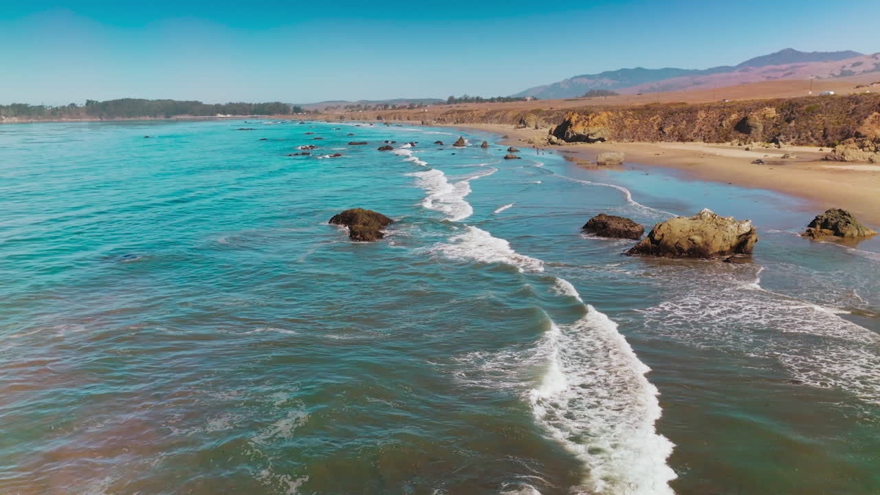 Mesmerizing picture of beautiful waves splashing by the shore. Sunny view of Morro Bay at Central Coast of California, USA.