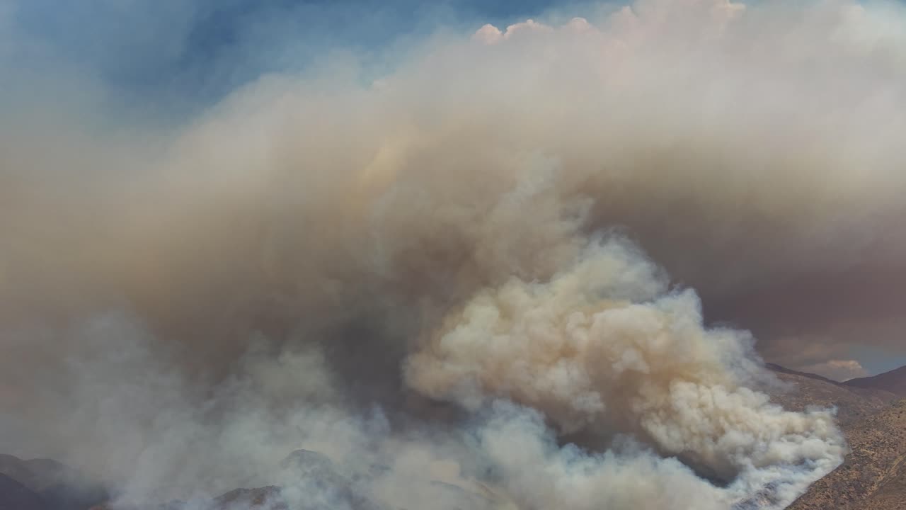 Vista cinematografica aerea ravvicinata con drone di denso fumo che si alza da un enorme incendio nelle Ande, Cile, video 4K