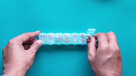 hands filling a weekly pill organizer