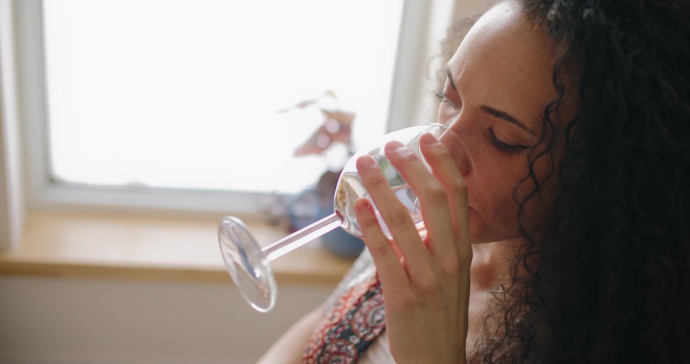 Woman Drinking Wine While Working on Laptop at Home