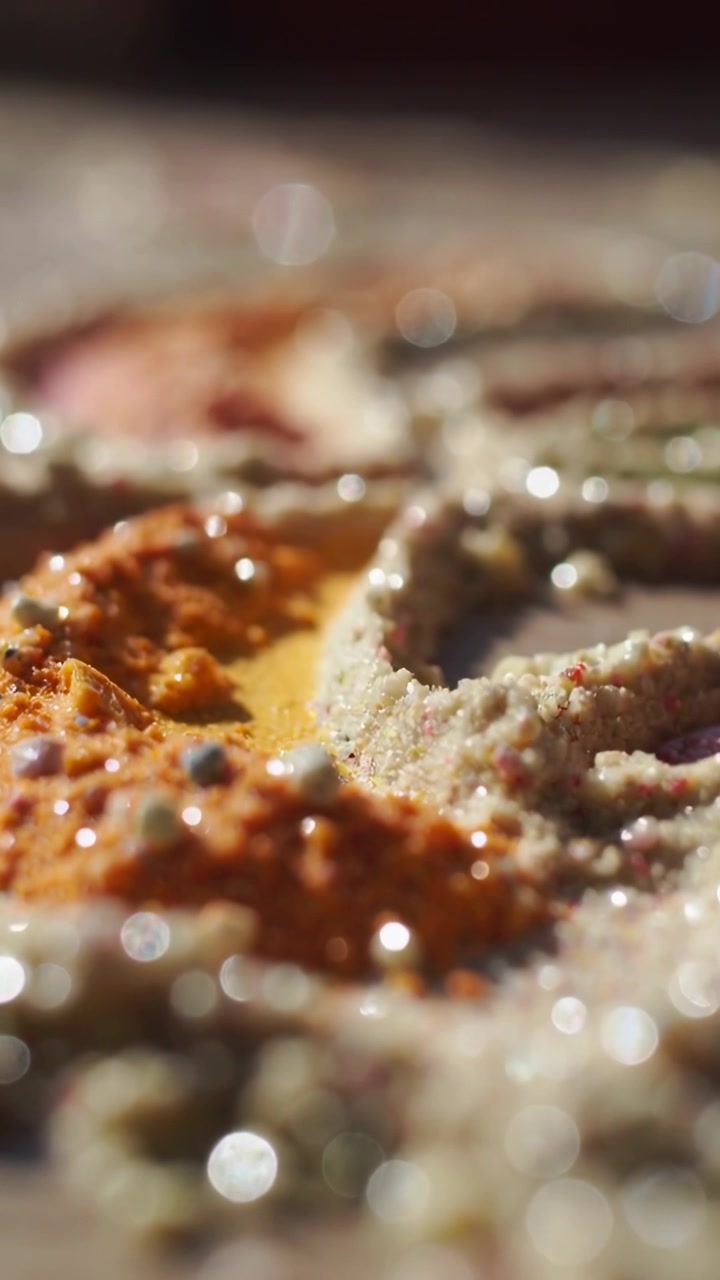 Video verticale: Telecamera che si sposta rivelando un cumulo arancione e un anello beige su un tavolo, mostrando la texture